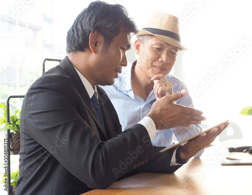 Asian business man present  information or marketing plan in digital tablet computer.