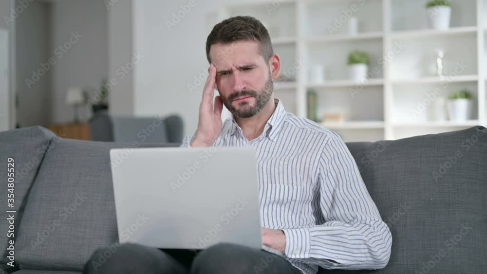 Tired Young Man with Laptop having Headache at Home Tired Young Man with Laptop having Headache at Home