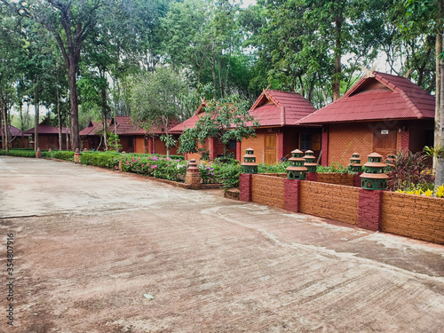 The row of cubicle or guesthouse made by red brick among abundance forest. 