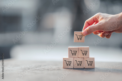 Sale volume increase make business grow, Wood cube with icon graph and shopping cart symbol.
