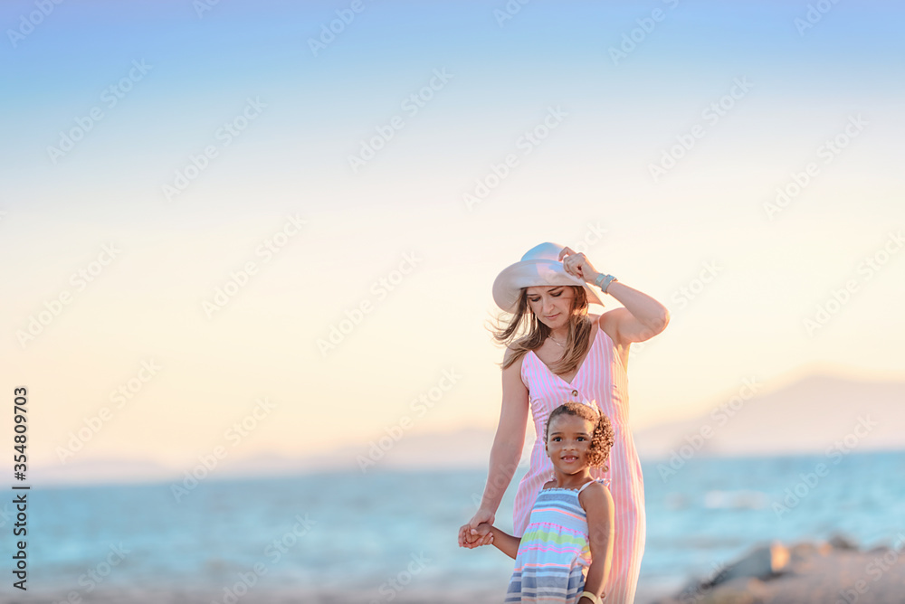 Young mother with her daughter walking at the promenade alley