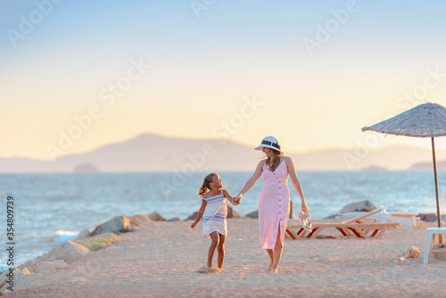 Young mother with her daughter walking at the promenade alley
