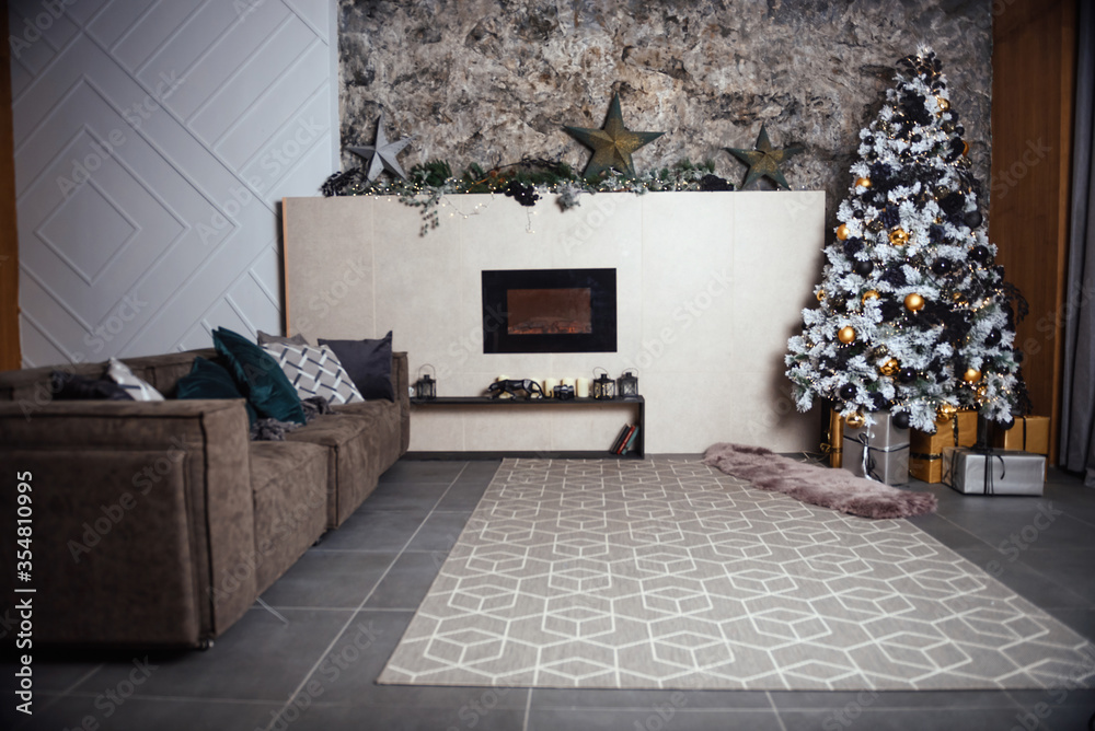 Fototapeta premium Winter decoration. decoration of the shelf for the new year or Christmas. candles, Christmas tree, books, bows and bumps