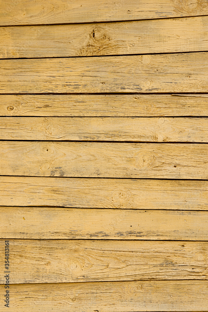 Texture of a yellow fence made of wooden boards