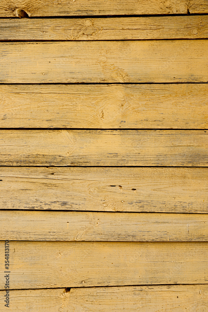 Texture of a yellow fence made of wooden boards