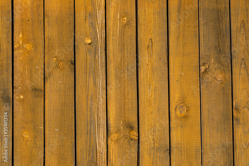 Texture of a yellow fence made of wooden boards