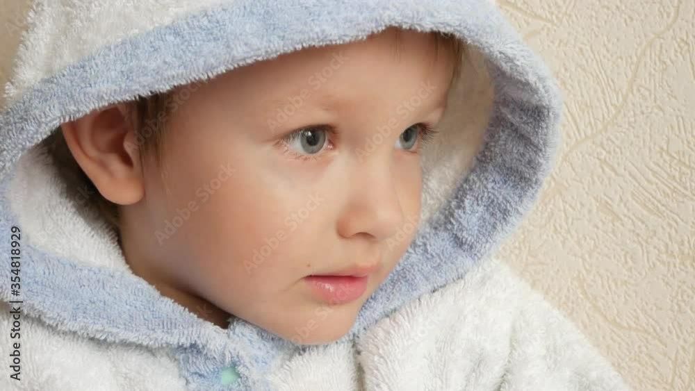 A beautiful baby dressed a white robe with a hood A beautiful baby dressed a white robe with a hood