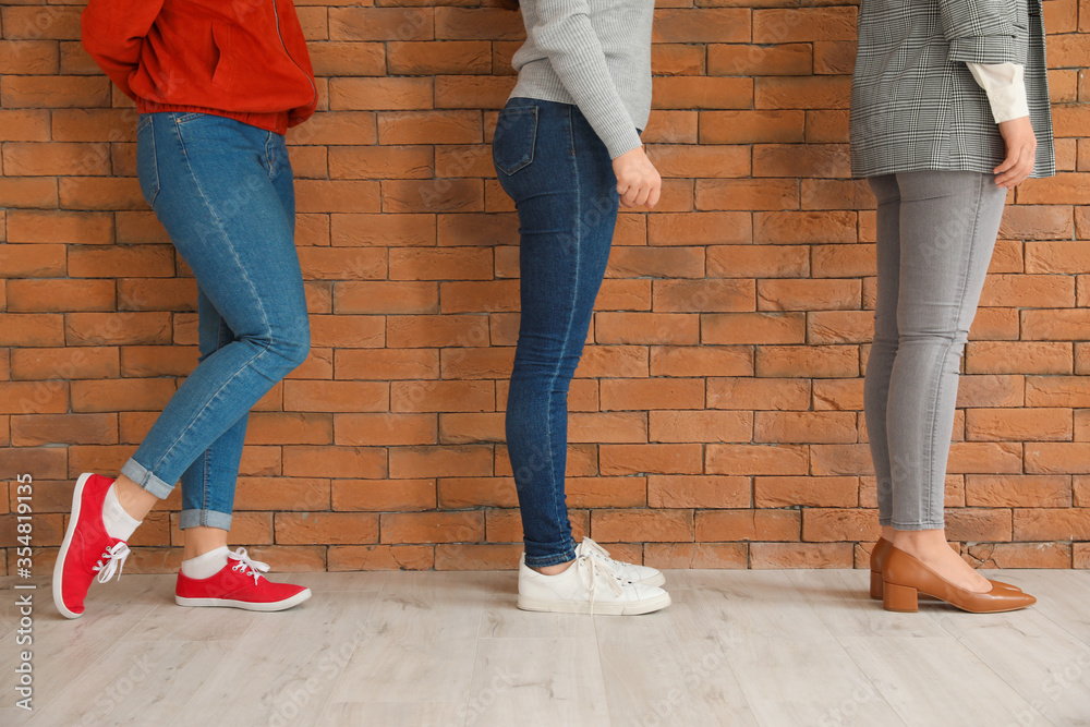 People standing near brick wall. Concept of social distance during coronavirus epidemic