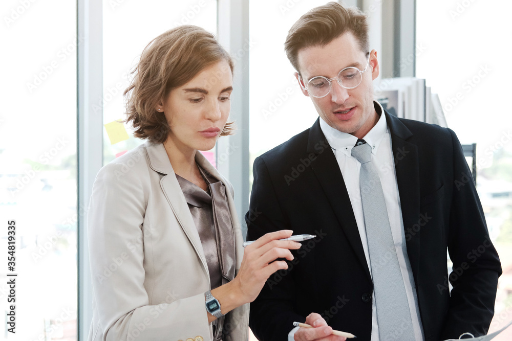Successful businessman and businesswoman meeting and holding pen for write good ideas in modern office Successful businessman and businesswoman meeting and holding pen for write good ideas in modern office