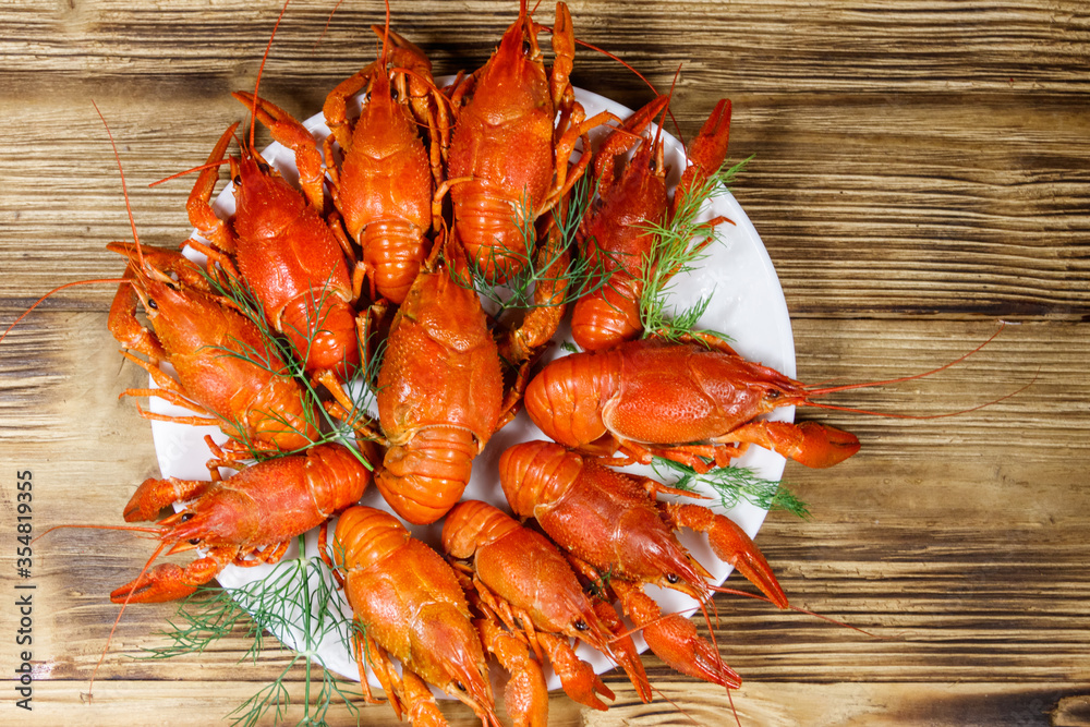 Boiled crayfish in plate on wooden table. Top view Boiled crayfish in plate on wooden table. Top view