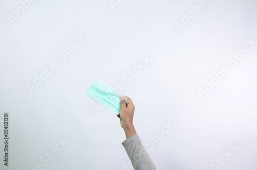 A man hand lifts a medical mask on a white background