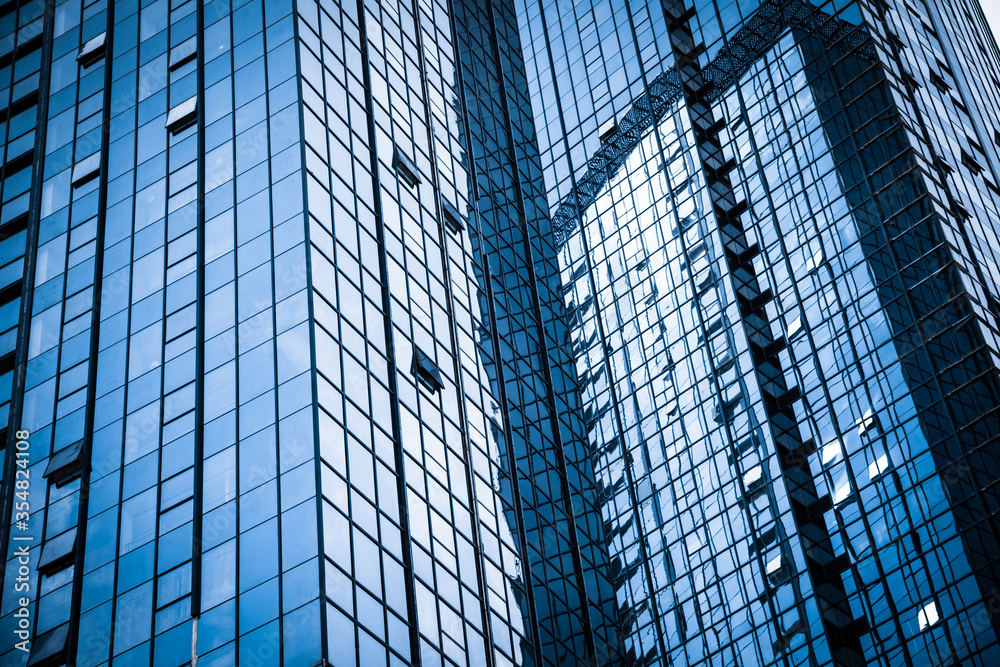 Modern glass building reflecting skyscrapers