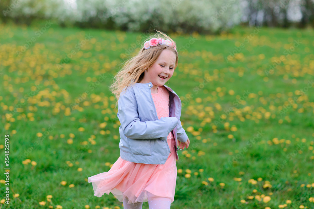 Pretty child girl smiling and playing in flowers of the garden, blooming trees, cherry, apples. Pretty child girl smiling and playing in flowers of the garden, blooming trees, cherry, apples.