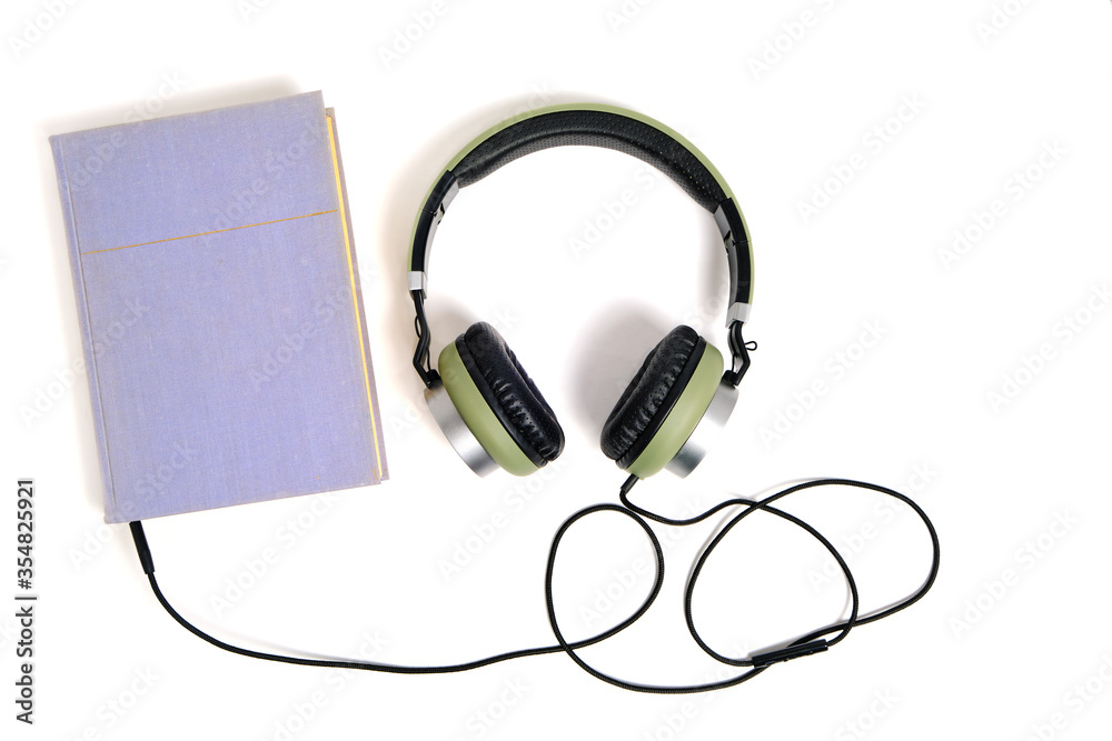 Lilac book and headphones on a white background. Listen to audiobooks online. Lilac book and headphones on a white background. Listen to audiobooks online.