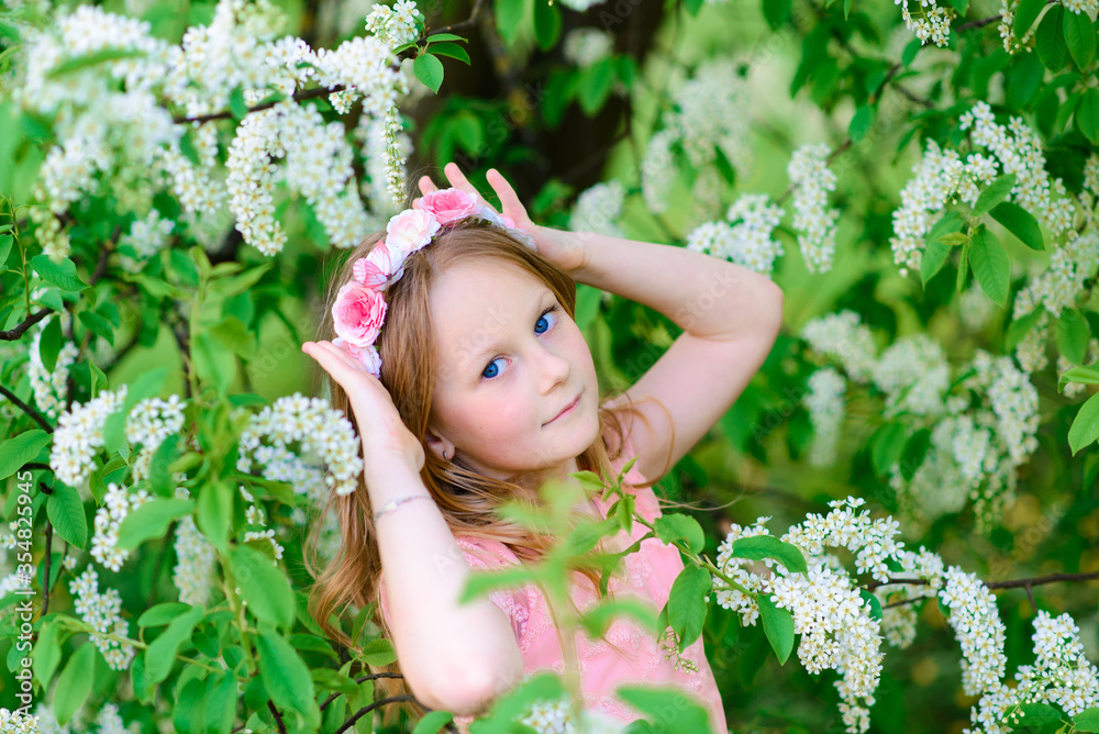 Pretty child girl smiling and playing in flowers of the garden, blooming trees, cherry, apples. Pretty child girl smiling and playing in flowers of the garden, blooming trees, cherry, apples.