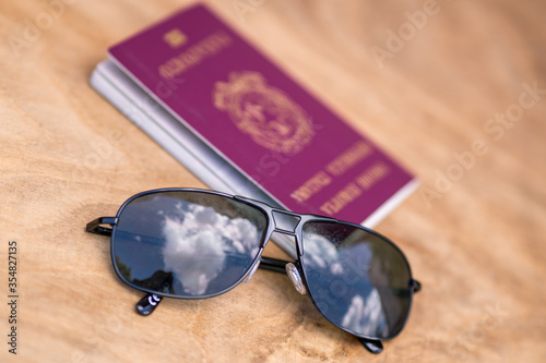Summer vacation concept. Sunglasses and Italian passport on a sandy beach