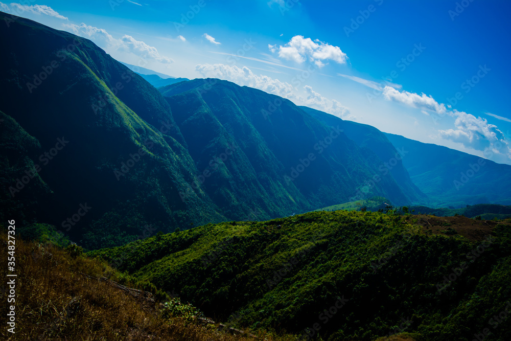 Natural view of the folded mountains and lush green valleys with clear sky and clouds of Cherrapunji, Meghalaya, North East India

