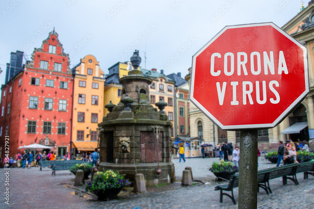 Corona virus stop sign with view of historic old town in Stockholm, Sweden. Warning about epidemic quarantine. Coronavirus disease pandemic. COVID-2019 alert sign