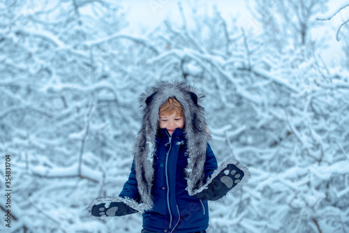 Winter child. Little child boy walking in winter field. Concept winter Kids and nature. Childhood memories - beautiful snowy winter over meadow. © Volodymyr