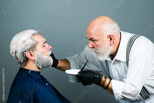 Process of dyeing hair for man at beauty salon, male closeup portrait. Dying hair of man. Bearded man in beauty salon. photo