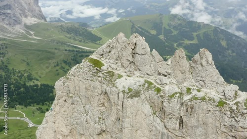 Aerial panning of rocky mountain peak against cloudy sky, drone flying over natural landscape - Dolomites, Italy photo