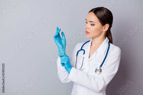 Photo of attractive family doc skilled experienced professional surgeon take on latex gloves prepare to operation wear medical uniform lab coat stethoscope isolated grey background