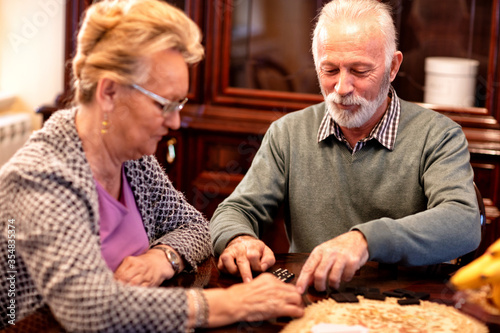 Senior couple having fun while playing dominos