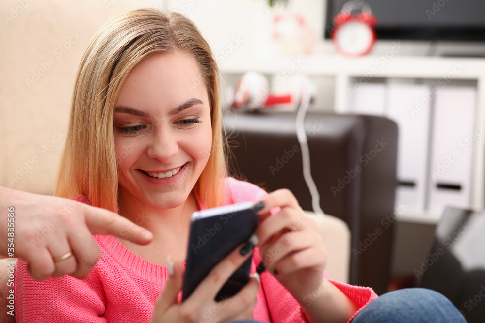 young pretty blond womansit on sofa hold smartphone in hands chat with friends young pretty blond womansit on sofa hold smartphone in hands chat with friends