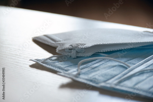 Two protective blue medical face masks on the edge of the table. The concept of safety and prevention during an epidemic of viral infection COVID-19