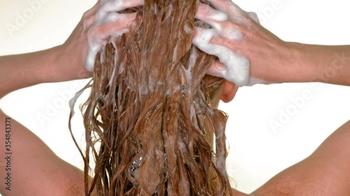 Anti-dandruff shampoo. Treatment of dandruff with anti-dandruff care shampoo. A young woman washes her head with shampoo. Foam on the head. photo