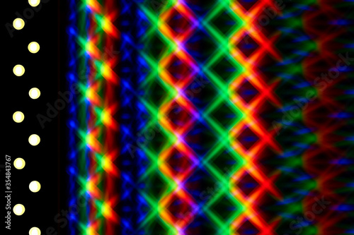 Photo of a diffraction pattern from a line of LEDs. Image was obtained using a twin diffraction grating. Beautiful play of light from intersecting brightly colored rainbow light spots