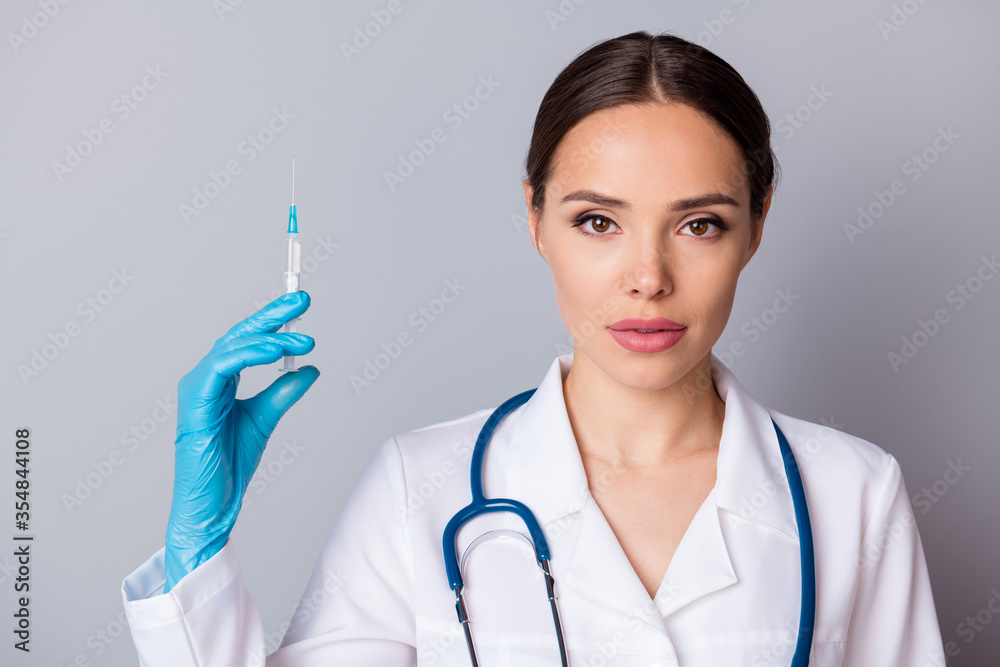Closeup photo of professional doc serious nurse hold syringe preparing patients vaccination antibiotic wear latex gloves medical uniform lab coat stethoscope isolated grey background Closeup photo of professional doc serious nurse hold syringe preparing patients vaccination antibiotic wear latex gloves medical uniform lab coat stethoscope isolated grey background