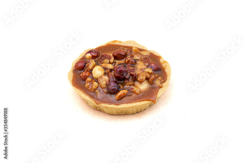 A round cake basket with condensed milk and nuts. Close-up on white background