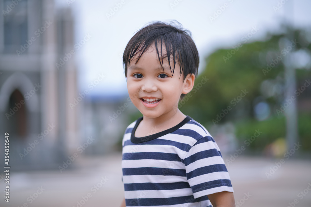 portrait of a boy looking and smiling to camera  - obrazy, fototapety, plakaty 
