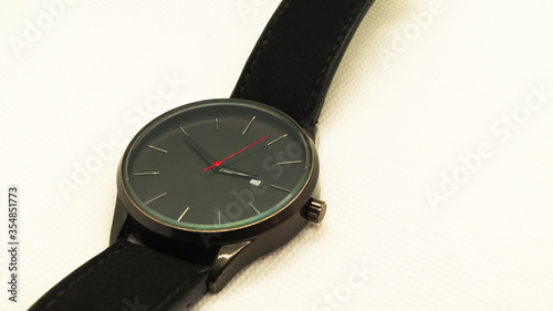 Black men's wristwatch with a red arrow on a white background. Clock without numbers. Men's accessory. Place for text.