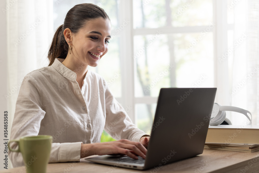 Happy woman using her laptop at home Happy woman using her laptop at home