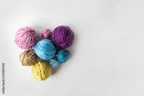 Multicolored Wool skeins in heart shape on light background. Copy space. Top view. Knitting as lovely hobby.