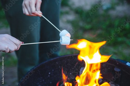 people grill marshmallows on coals