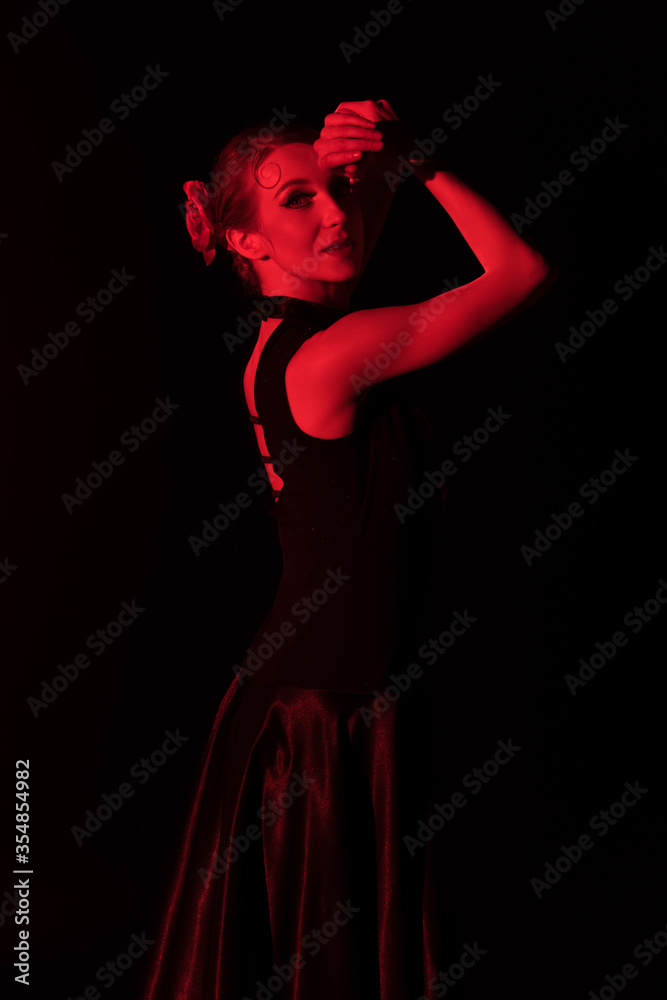 red lighting on attractive flamenco dancer in dress isolated on black
