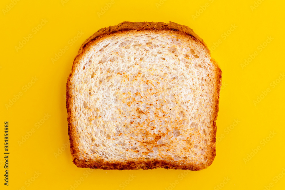 Close up photo of toasted bread on yellow background. Top view of roasted toast. Fried bread for breakfast. Close up photo of toasted bread on yellow background. Top view of roasted toast. Fried bread for breakfast.