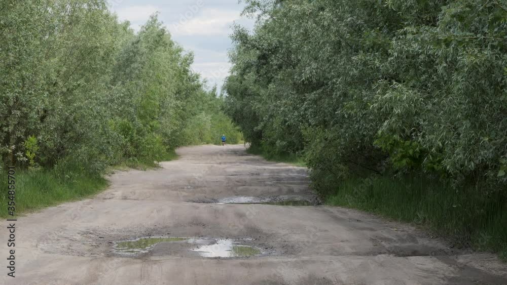 healthy lifestyle. man runs along a country road in green thickets 2020 healthy lifestyle. man runs along a country road in green thickets 2020