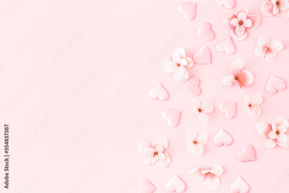 Flowers composition. Pink flowers hearts on pastel pink background. Flat lay, top view, copy space