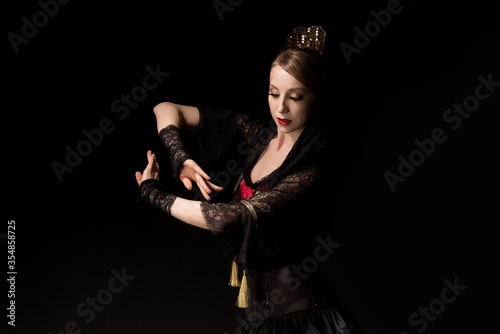 attractive dancer in dress gesturing while dancing flamenco isolated on black