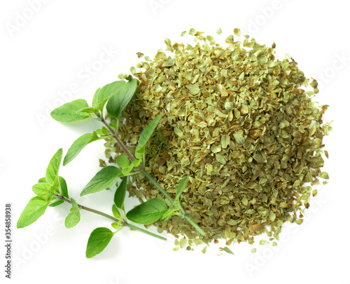 dried oreagon flakes with fresh oregano leaves isolated on white background, top view