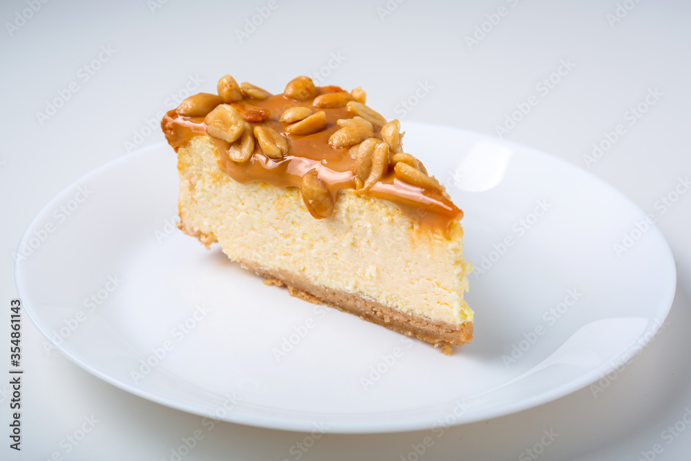 Piece of cheesecake with caramel and peanuts coating