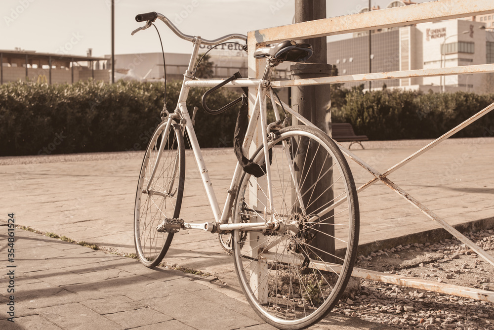 bicycle parked near the iron fence. photo in the old style of a bicycle on the street. cycling bicycle parked near the iron fence. photo in the old style of a bicycle on the street. cycling