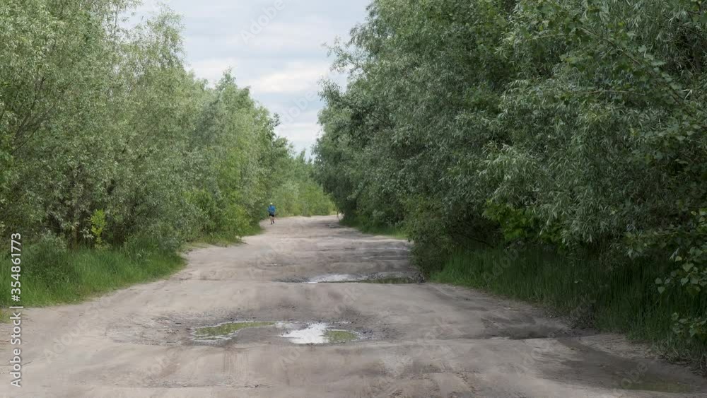 healthy lifestyle. man runs along a country road in green thickets 2020 healthy lifestyle. man runs along a country road in green thickets 2020