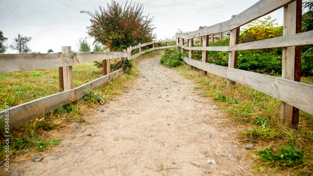 Long wooden fence or hedge on farm at countryside