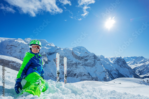 Little boy having fun skiing in Alpine mountains portrait with panorama copy space