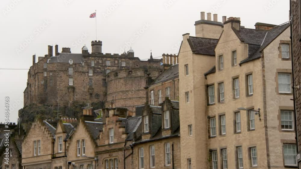 Low angle lockdown shot of British flag on historic castle in city against sky - Edinburgh, Scotland Low angle lockdown shot of British flag on historic castle in city against sky - Edinburgh, Scotland